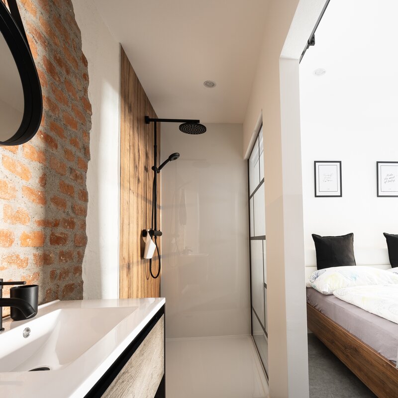 Badezimmer im Loftstyle mit Blick in den Schlaf- wohnbereich | © @wolfistraunseeblick
