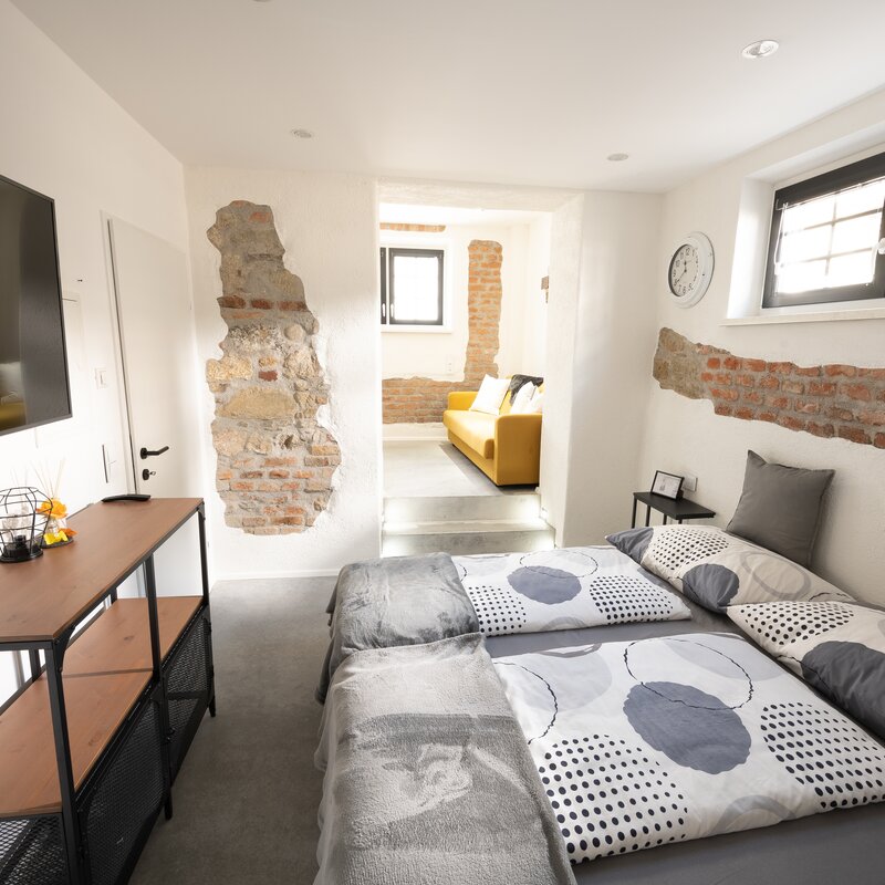 Von unserem kuscheligen Bett aus kann man direkt zum TV & in den Wohnbereich sehen | © @wolfistraunseeblick