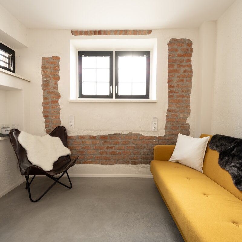 Der separate Wohnbereich mit Sofa, Schreibtisch, Kaffeemaschine, Wasserkocher etc. lädt für gemütliche Stunden ein | © @wolfistraunseeblick