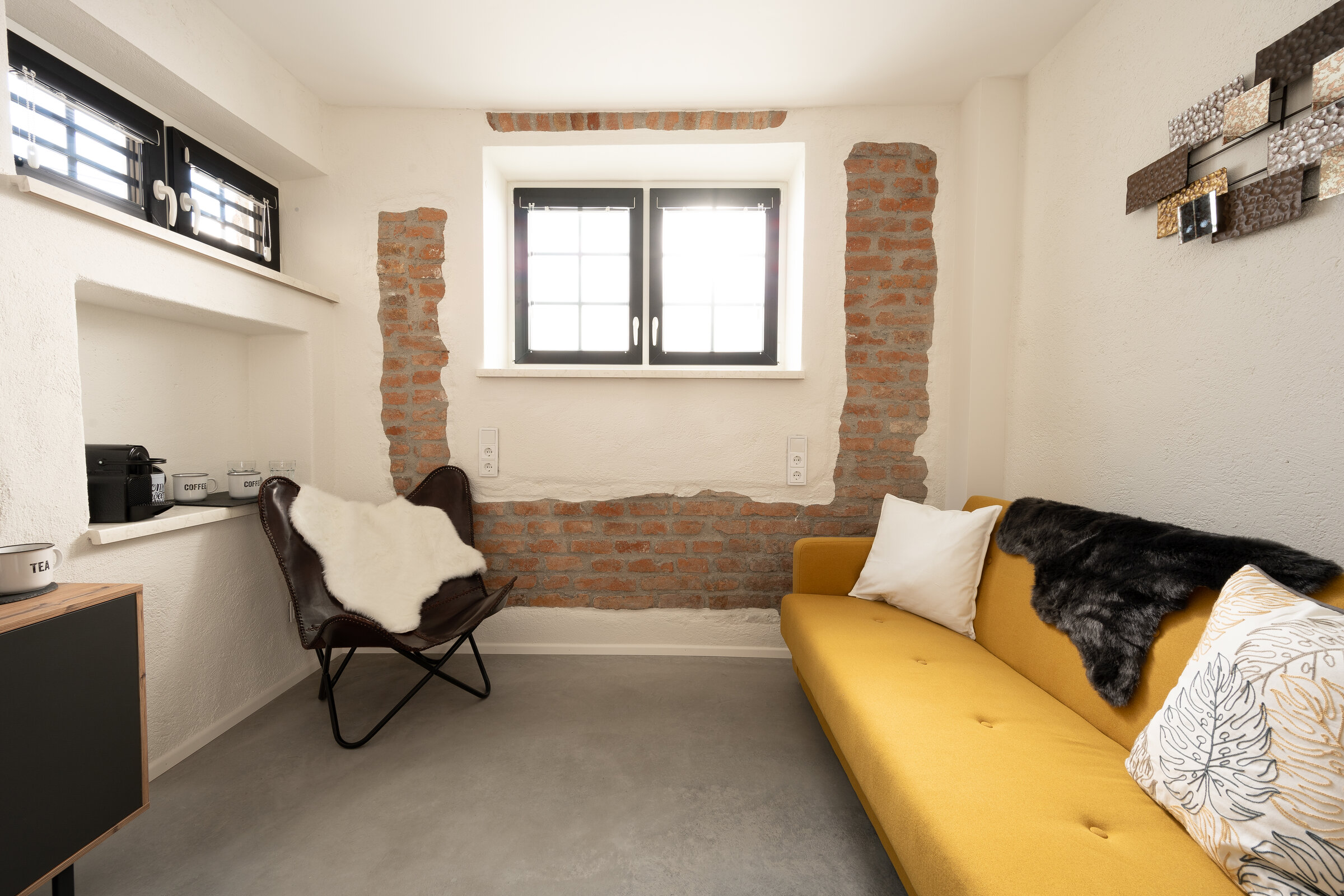 Der separate Wohnbereich mit Sofa, Schreibtisch, Kaffeemaschine, Wasserkocher etc. lädt für gemütliche Stunden ein | © @wolfistraunseeblick