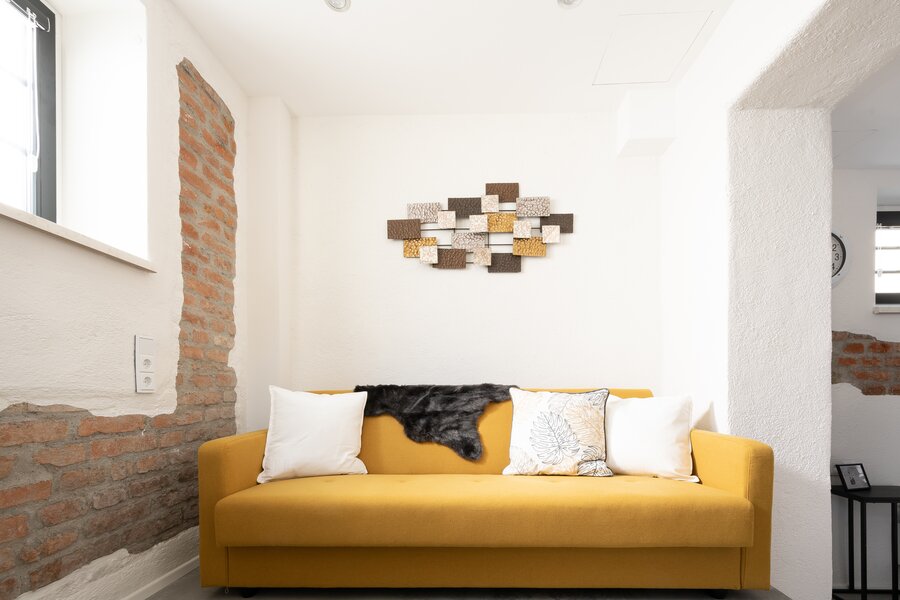 The colourful couch is located in the second room and gives it a cosy, spacious atmosphere and offers an additional sleeping option | © @wolfistraunseeblick