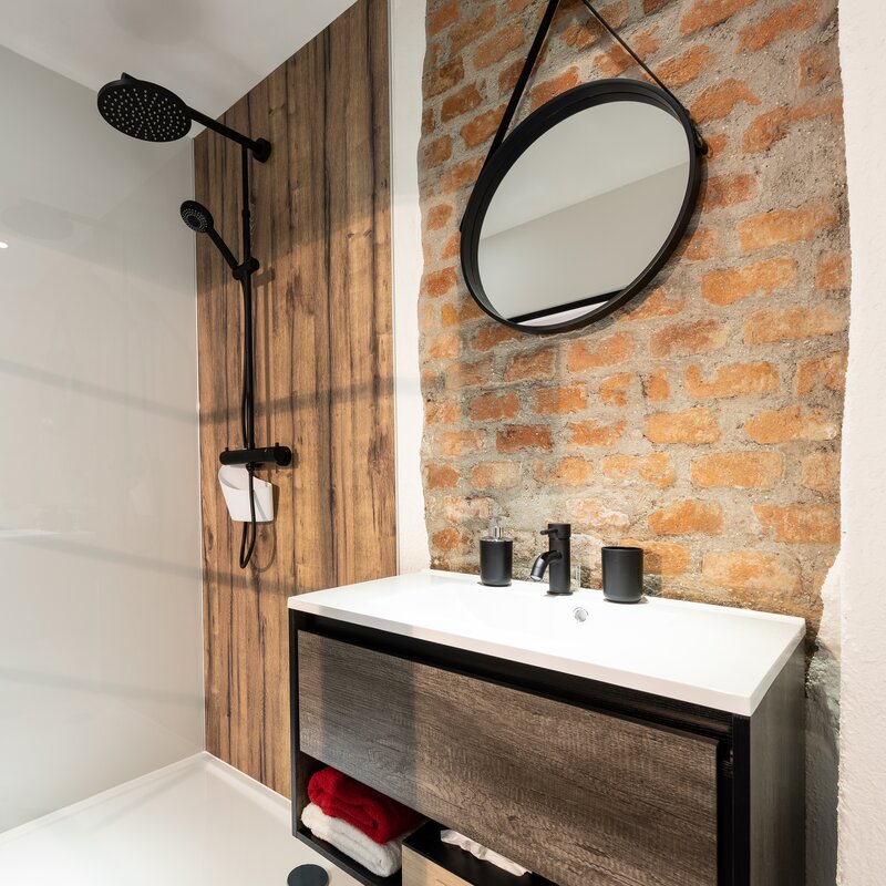 Loft-style bathroom with spacious rain shower and view into the living/sleeping area  | © @wolfistraunseeblick