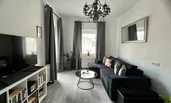 Gemütliches Wohnzimmer mit Schlafofa, Balkon und Leseecke | © @wolfistraunseeblick