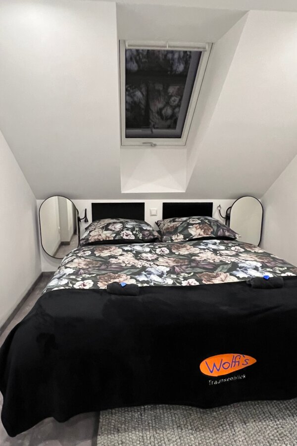 Cosy, small bedroom with a view of the stars through the skylight | © @wolfistraunseeblick