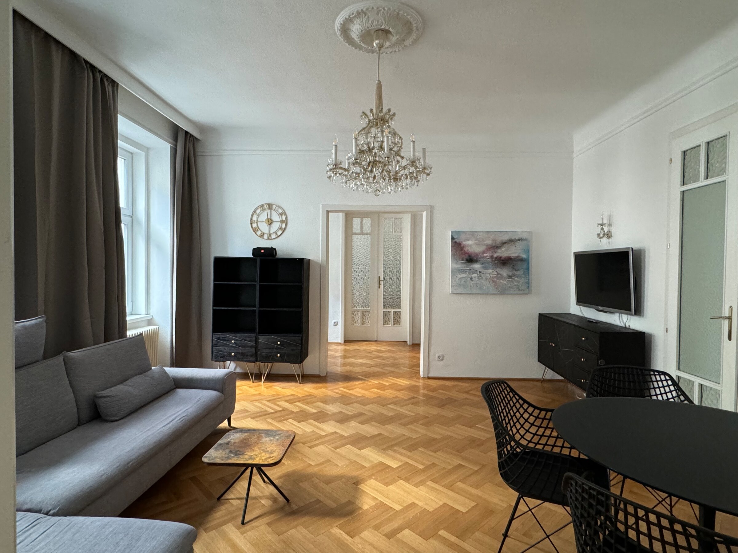 Helles Wohnzimmer mit Parkettboden & Kronleuchter – 3-Zimmer Wohnung zur Kurzzeitmiete, Wohnen auf Zeit 1 bis 6 Monate, Wien