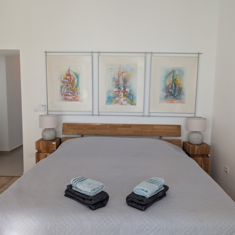 Helles Schlafzimmer mit Kunstdrucken & Holzmöbeln – 2-Zimmer Wohnung zur Kurzzeitmiete & Wohnen auf Zeit für 1 bis 6 Monate in Wien