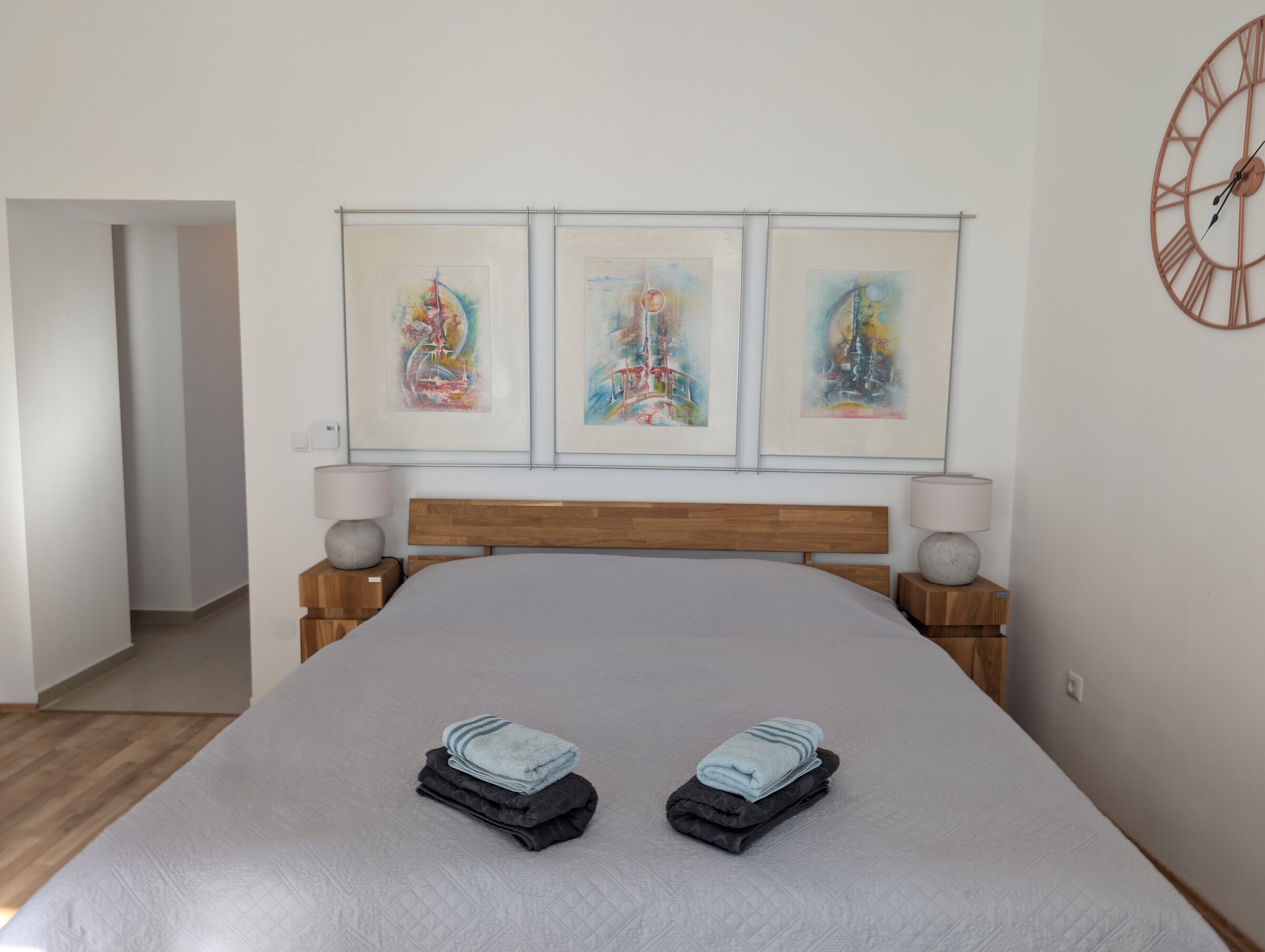 Helles Schlafzimmer mit Kunstdrucken & Holzmöbeln – 2-Zimmer Wohnung zur Kurzzeitmiete & Wohnen auf Zeit für 1 bis 6 Monate in Wien