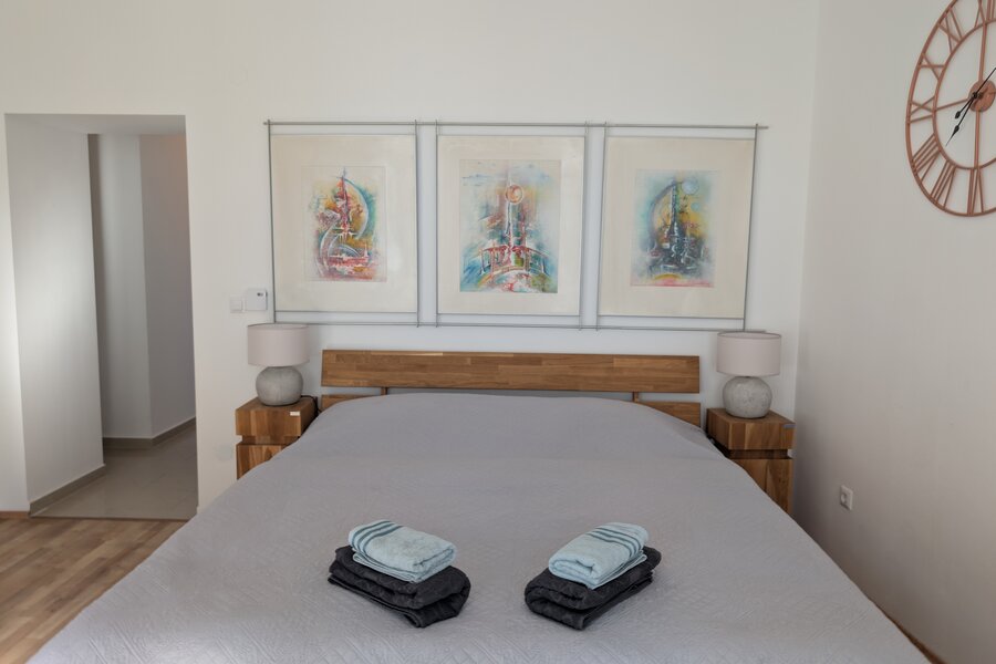 Helles Schlafzimmer mit Kunstdrucken & Holzmöbeln – 2-Zimmer Wohnung zur Kurzzeitmiete & Wohnen auf Zeit für 1 bis 6 Monate in Wien