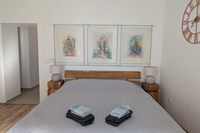 Helles Schlafzimmer mit Kunstdrucken & Holzmöbeln – 2-Zimmer Wohnung zur Kurzzeitmiete & Wohnen auf Zeit für 1 bis 6 Monate in Wien