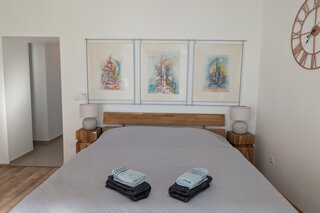 Helles Schlafzimmer mit Kunstdrucken & Holzmöbeln – 2-Zimmer Wohnung zur Kurzzeitmiete & Wohnen auf Zeit für 1 bis 6 Monate in Wien