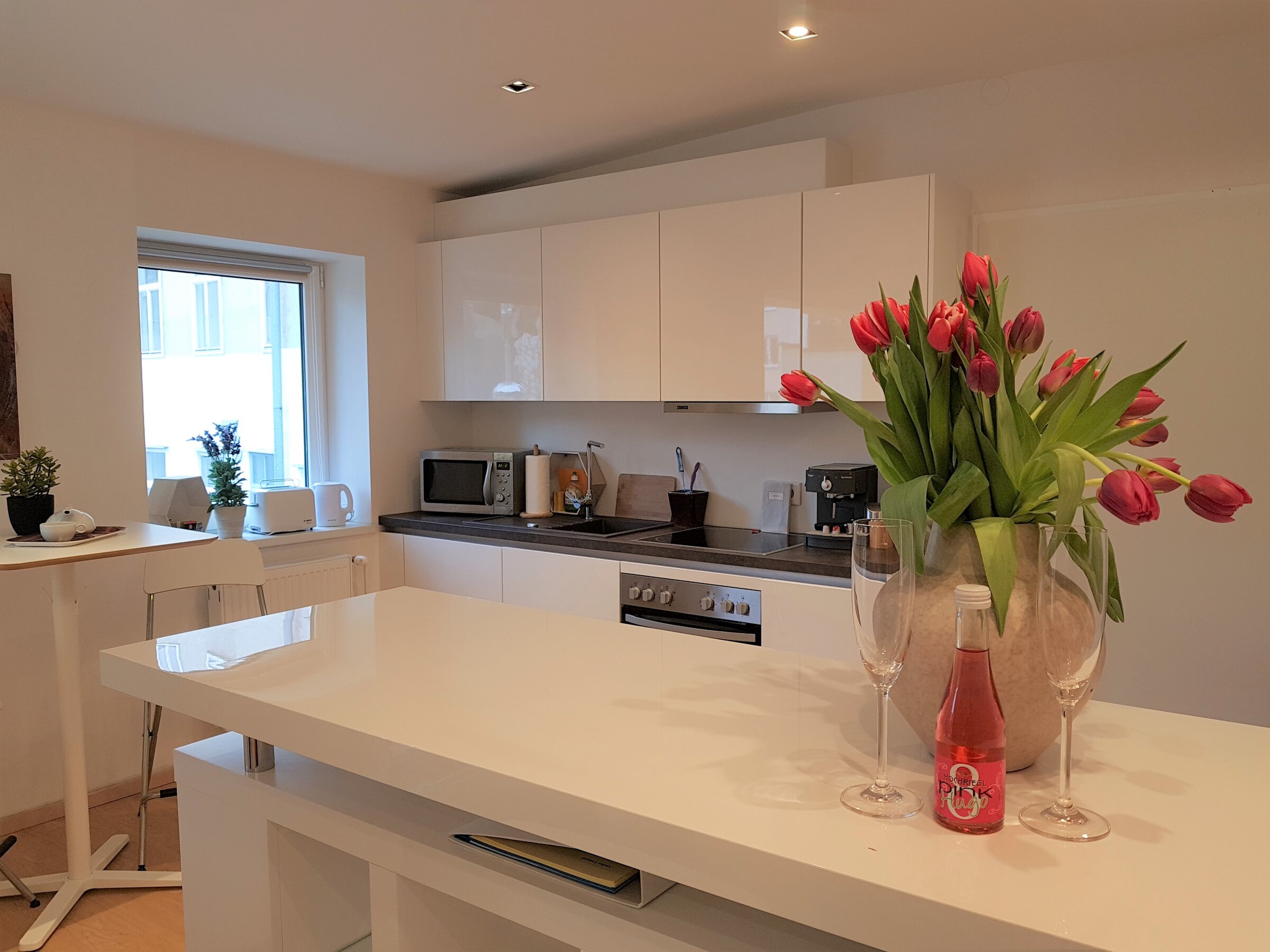 Bright kitchen with island & tulips: 1-room apartment for short-term rental & temporary housing for 1 to 6 months in Vienna