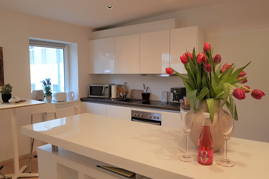 Bright kitchen with island & tulips: 1-room apartment for short-term rental & temporary housing for 1 to 6 months in Vienna