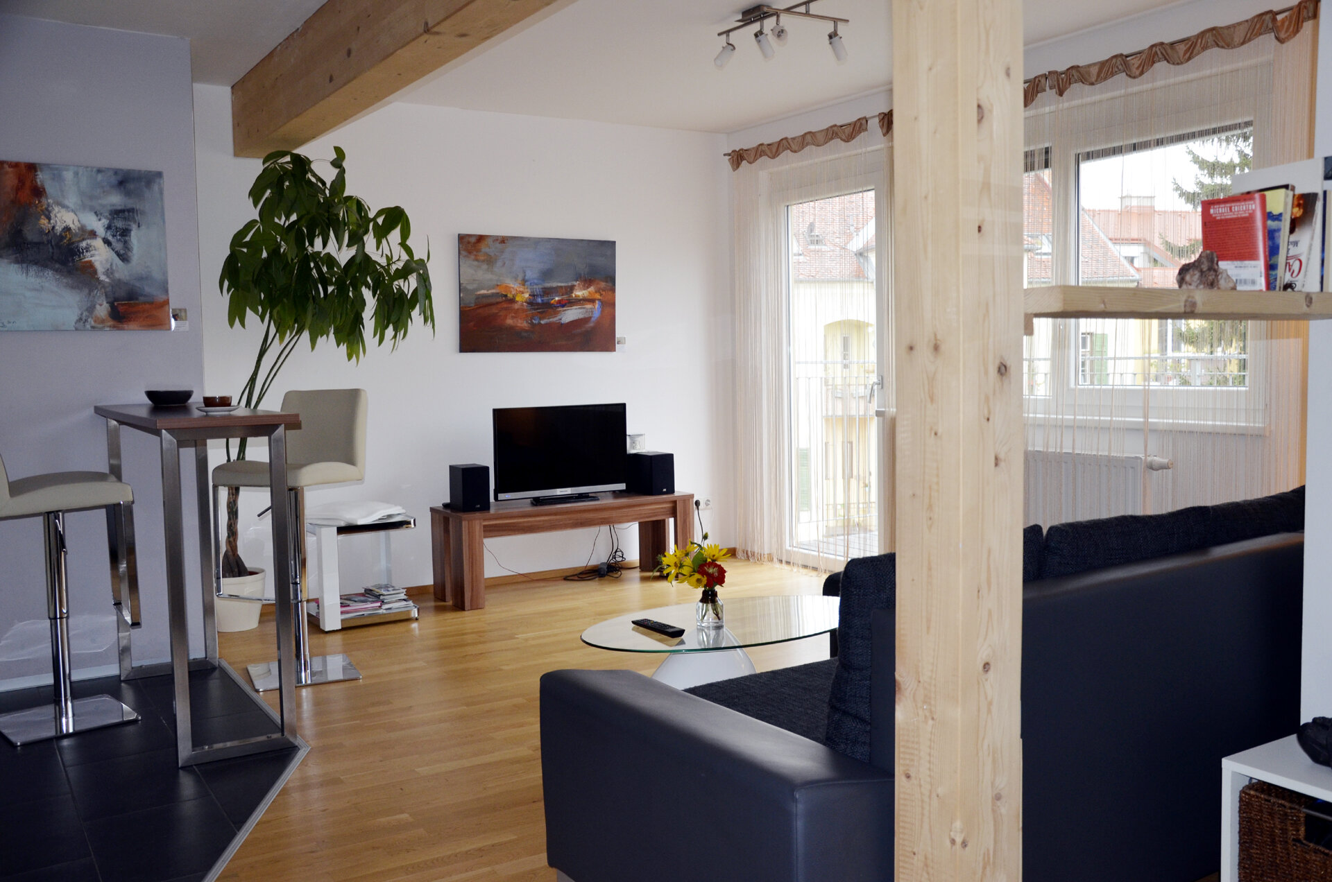Bright living room with wooden beams & modern TV area – 2-room apartment for short-term rental & temporary housing for 1 to 6 months in Graz