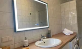Badezimmer mit Waschmaschine, Dusche und großem beheizten und beleuchteten Anti Beschlagsspiegel