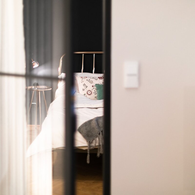 das Schlafzimmer betritt man durch eine Stahl-Glas-Tür