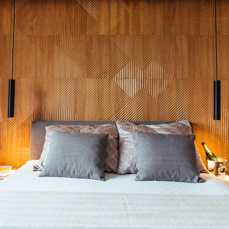 Stylish bedroom with wood panel wall: 2-room apartment for short-term rental & temporary housing for 1 to 6 months in Graz.