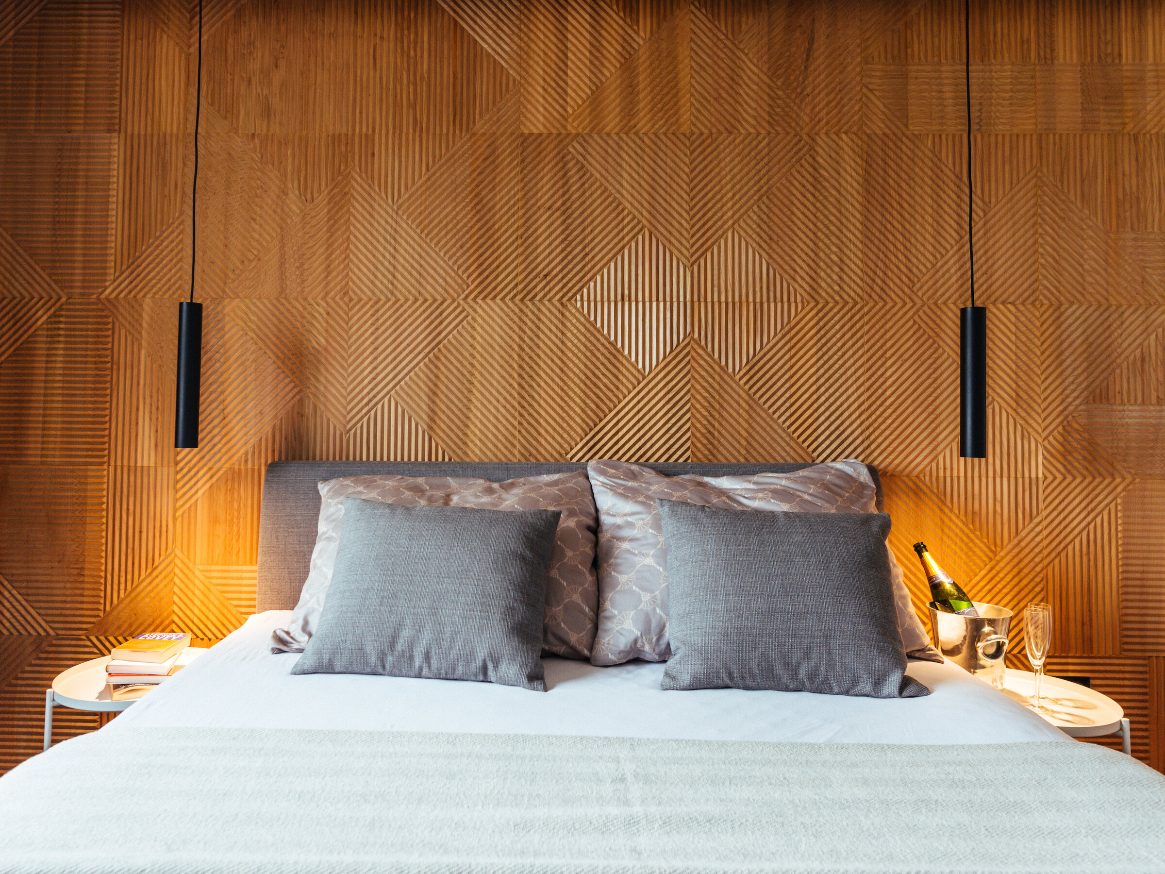 Stylish bedroom with wood panel wall: 2-room apartment for short-term rental & temporary housing for 1 to 6 months in Graz.
