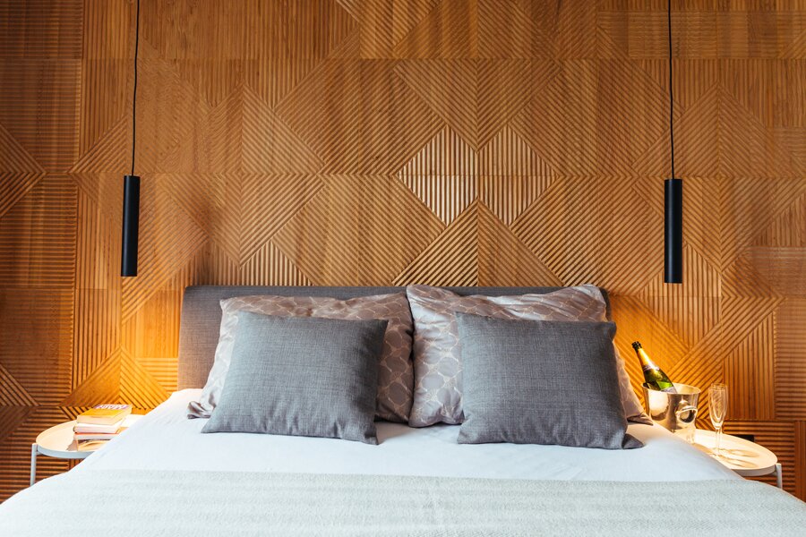 Stylish bedroom with wood panel wall: 2-room apartment for short-term rental & temporary housing for 1 to 6 months in Graz.