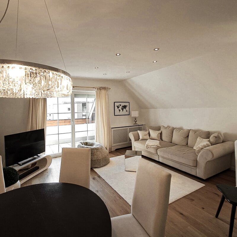 Helles Wohnzimmer mit Kristallleuchter & Dachschräge – 2-Zimmer Wohnung zur Kurzzeitmiete, Wohnen auf Zeit 1 bis 6 Monate, Salzburg
