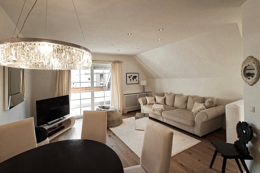 Helles Wohnzimmer mit Kristallleuchter & Dachschräge – 2-Zimmer Wohnung zur Kurzzeitmiete, Wohnen auf Zeit 1 bis 6 Monate, Salzburg
