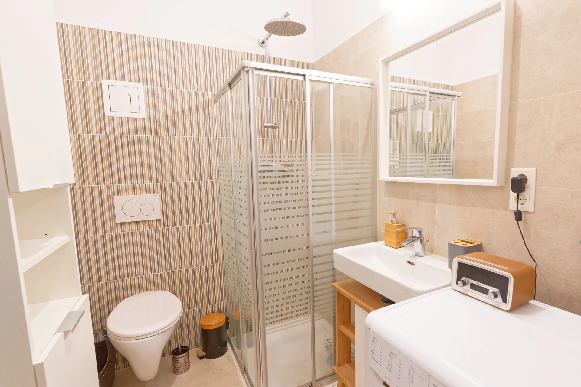 Badezimmer mit Dusche, Toilette, Waschschrank, Spiegel, Waschmaschine, Handtuchwärmer | © Sammer