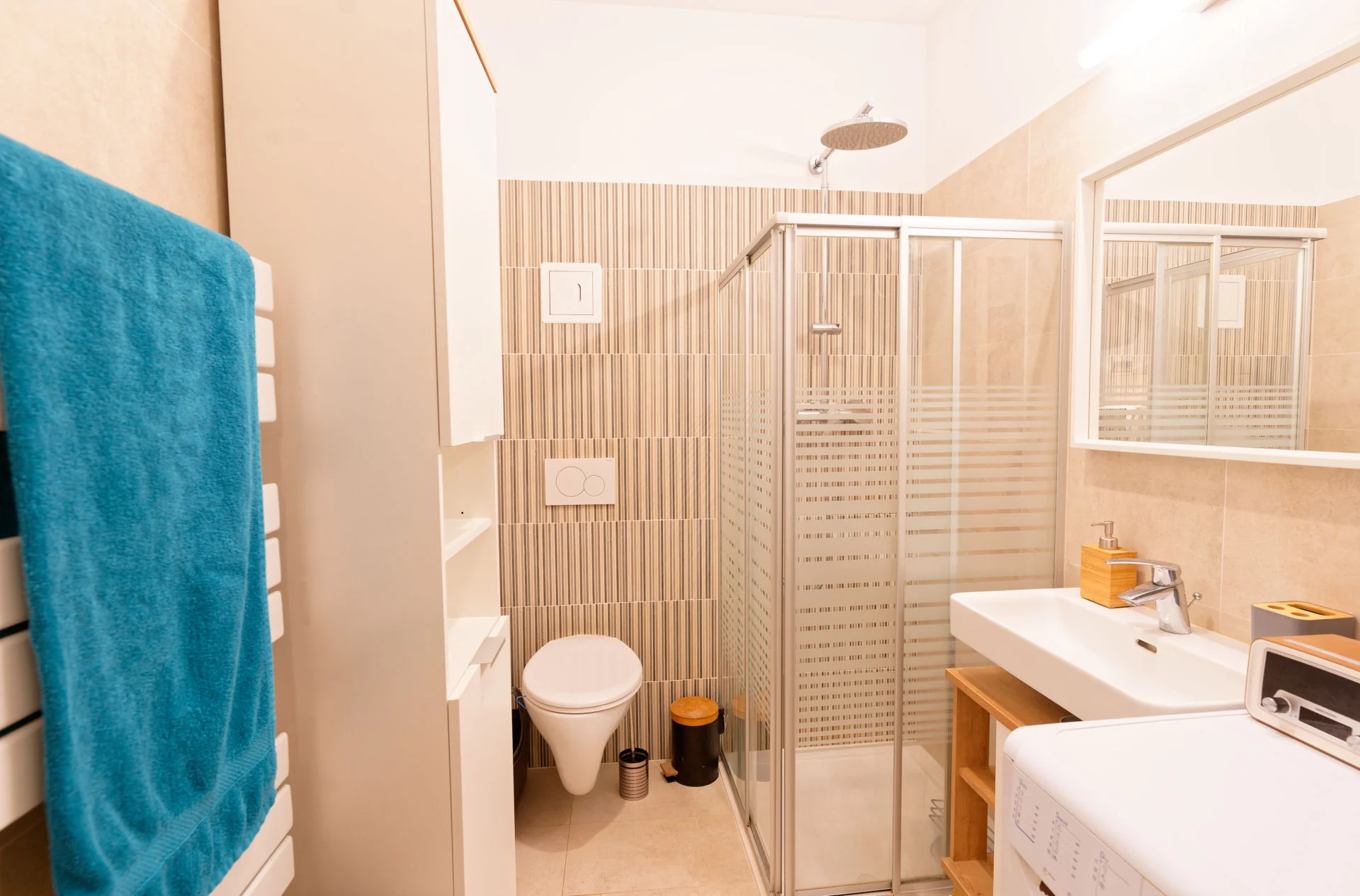 Badezimmer mit Dusche, Toilette, Waschschrank, Spiegel, Waschmaschine, Handtuchwärmer | © Sammer