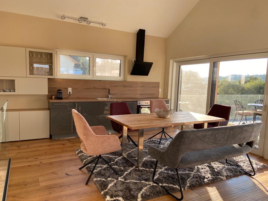 Open living & dining area with wooden table and modern kitchen – house for short-term rental & temporary housing for 1 to 6 months in Vasoldsberg
