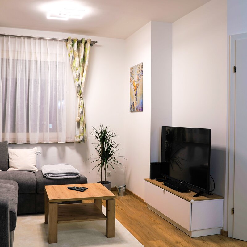Wohnzimmer mit sehr gemütlicher Couch, TV und Soundbar