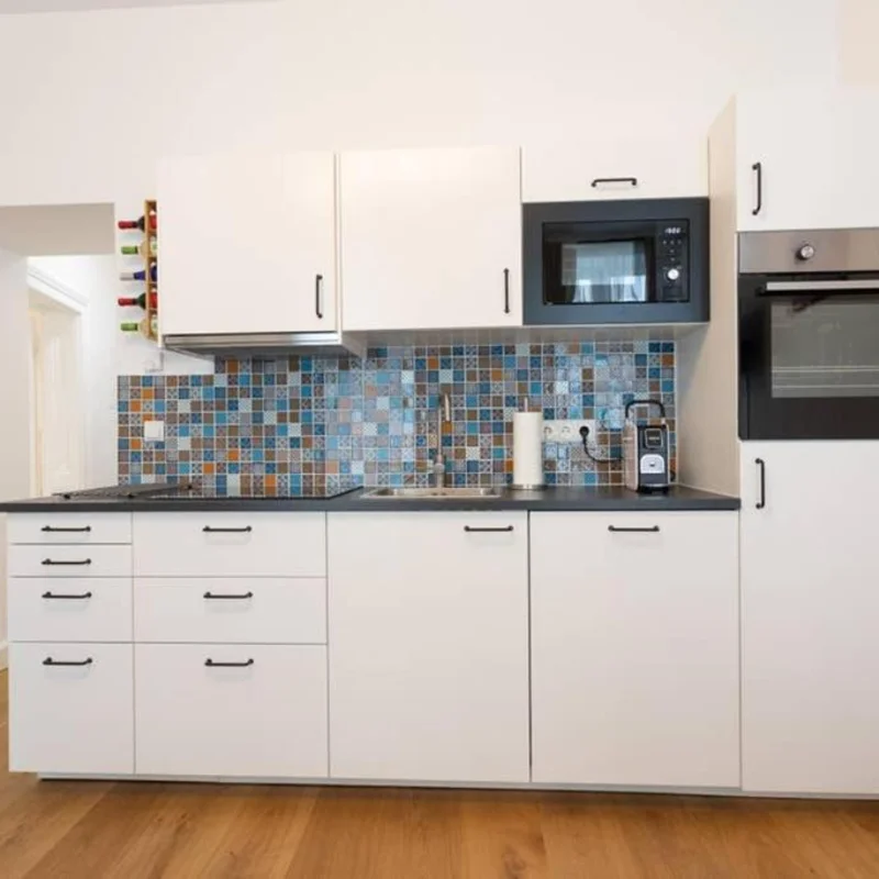 Küche mit Microwelle, Kochfeld und Backrohr