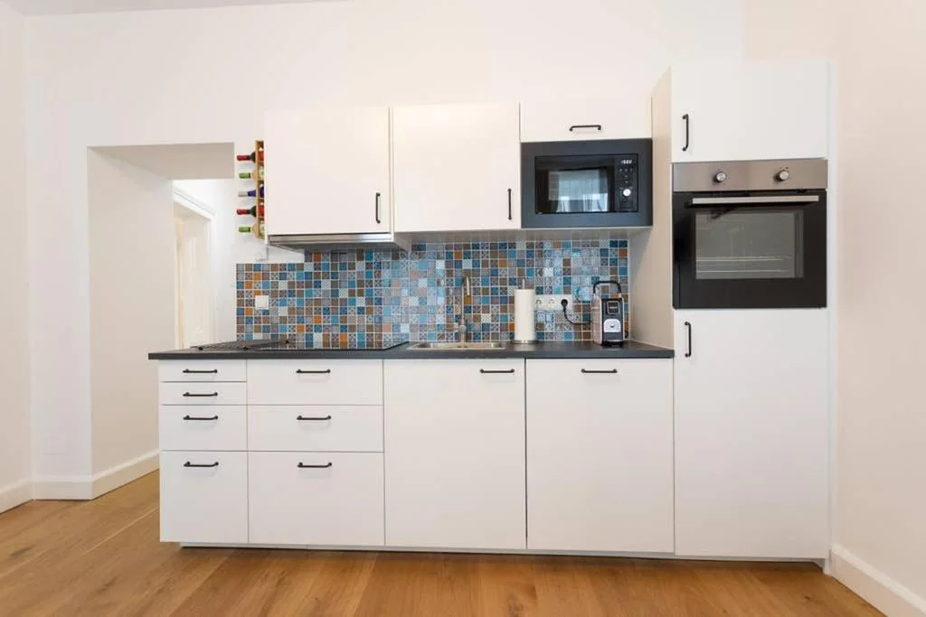Küche mit Microwelle, Kochfeld und Backrohr