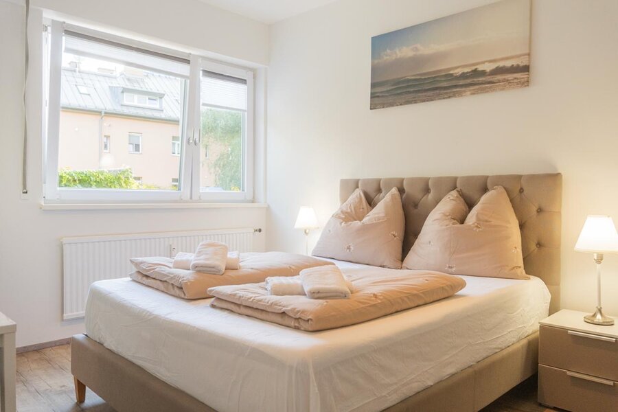 Helles Schlafzimmer mit Doppelbett & Fenster – 1-Zimmer Apartment zur Kurzzeitmiete & Wohnen auf Zeit für 1 bis 6 Monate in Innsbruck