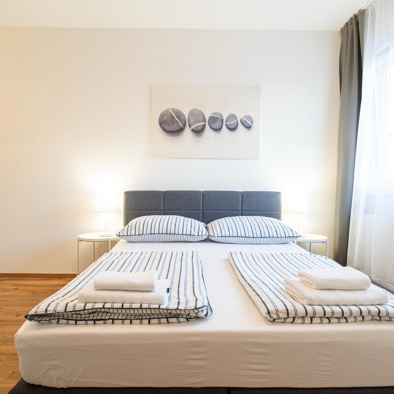Helles Schlafzimmer mit Doppelbett & modernem Stil – 1-Zimmer Apartment zur Kurzzeitmiete, Wohnen auf Zeit 1 bis 6 Monate, Innsbruck