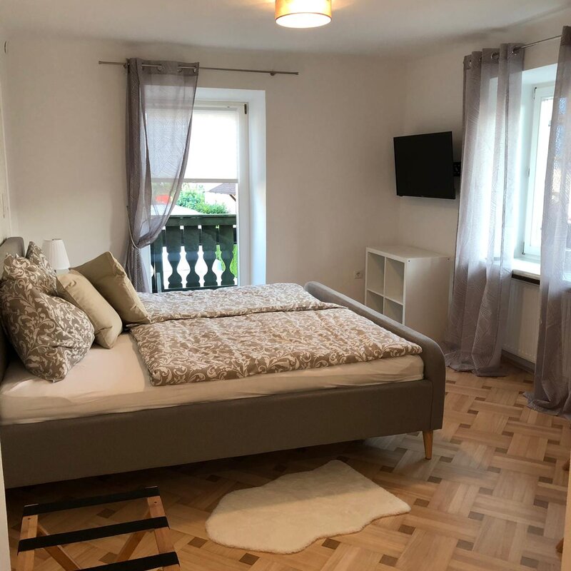 Helles Schlafzimmer mit Doppelbett & Balkon – 1-Zimmer Apartment zur Kurzzeitmiete & Wohnen auf Zeit für 1 bis 6 Monate in Anthering