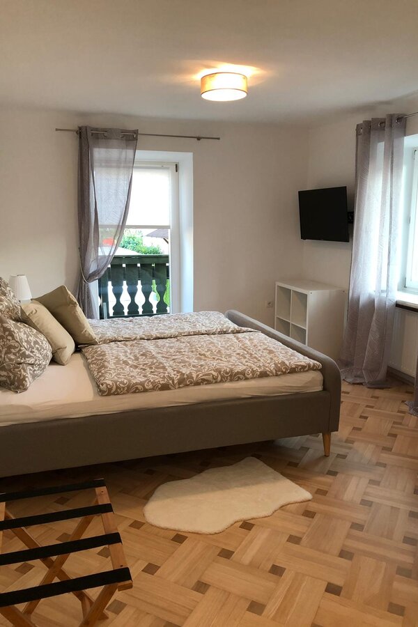 Helles Schlafzimmer mit Doppelbett & Balkon – 1-Zimmer Apartment zur Kurzzeitmiete & Wohnen auf Zeit für 1 bis 6 Monate in Anthering