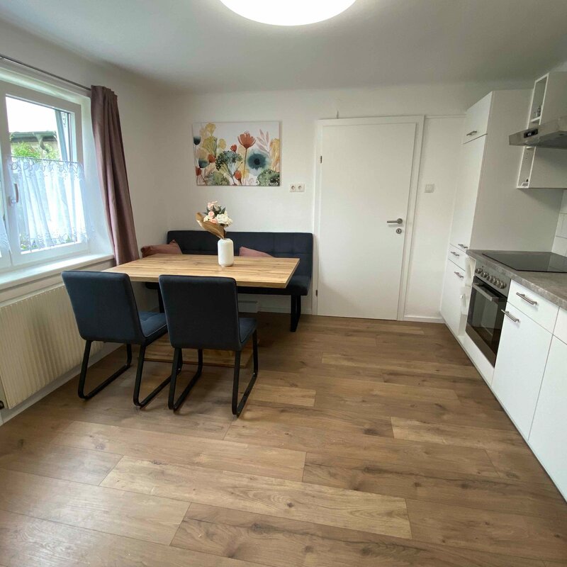 Wohnküche mit bequemer Sitzbank und TV.