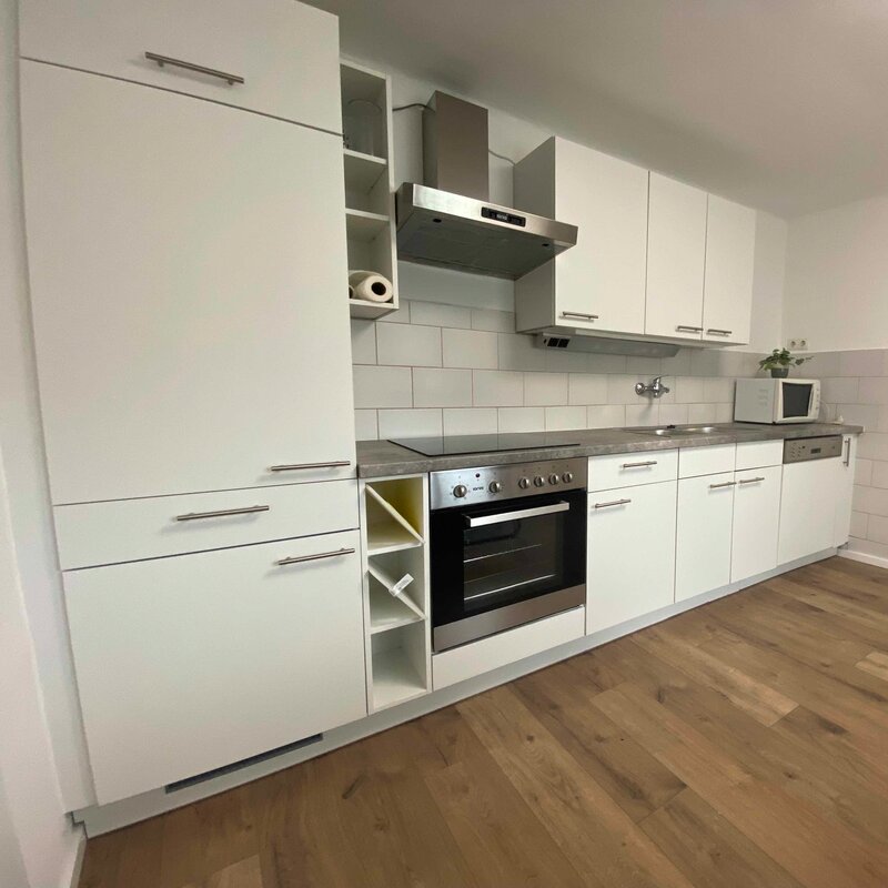 Küchenzeile mit Einbaukühlschrank, Herd u Backofen und Microwelle.