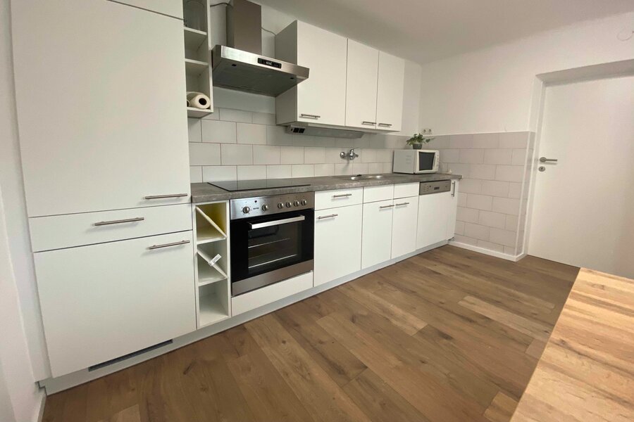 Küchenzeile mit Einbaukühlschrank, Herd u Backofen und Microwelle.