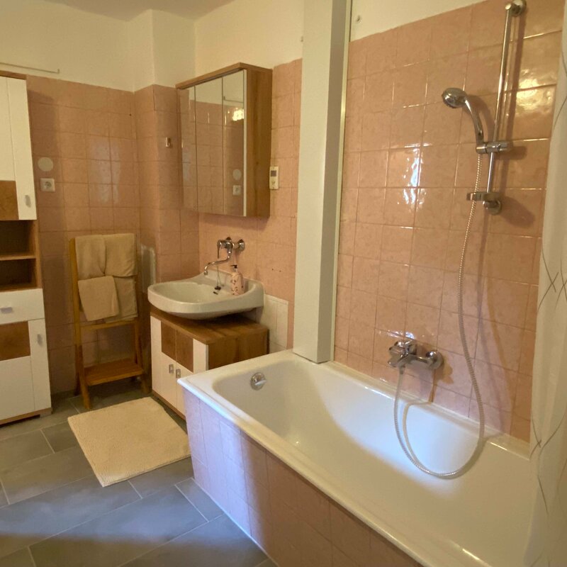 Badezimmer mit Wanne und WC (links)