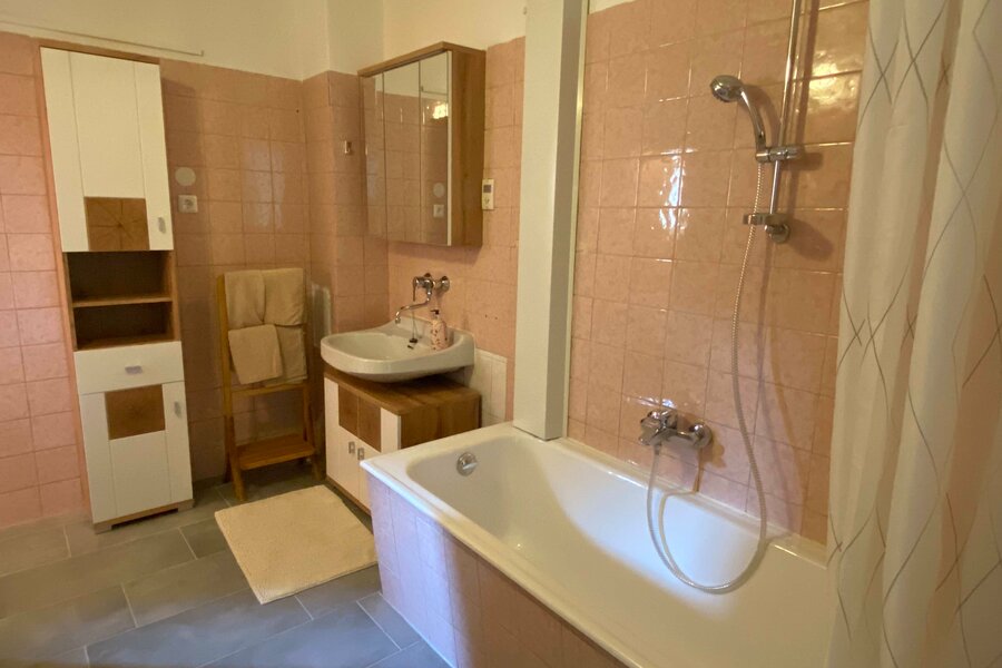 Badezimmer mit Wanne und WC (links)