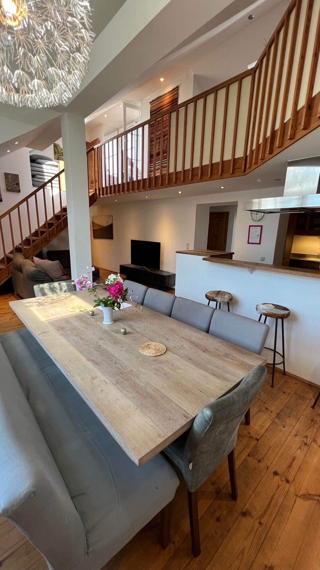 Unser großzügiges Wohn- und Esszimmer bildet das Herzstück der Wohnung, entworfen, um nahtlos Eleganz und Funktionalität zu vereinen. Die offene Raumgestaltung fördert ein geselliges Beisammensein, während die geschmackvolle Einrichtung und sanfte Beleuchtung eine warme, einladende Atmosphäre schaffen. Das Wohnzimmer, ausgestattet mit einer bequemen Sofalandschaft und einem Smart-TV, lädt zu gemütlichen Filmabenden ein. Der angrenzende Essbereich, mit einem modernen Tisch für 10 Personen, bietet den idealen Rahmen für gemeinsame Mahlzeiten. Große Fenster sorgen für reichlich Tageslicht, was diesen Raum perfekt für Entspannung und Unterhaltung macht.