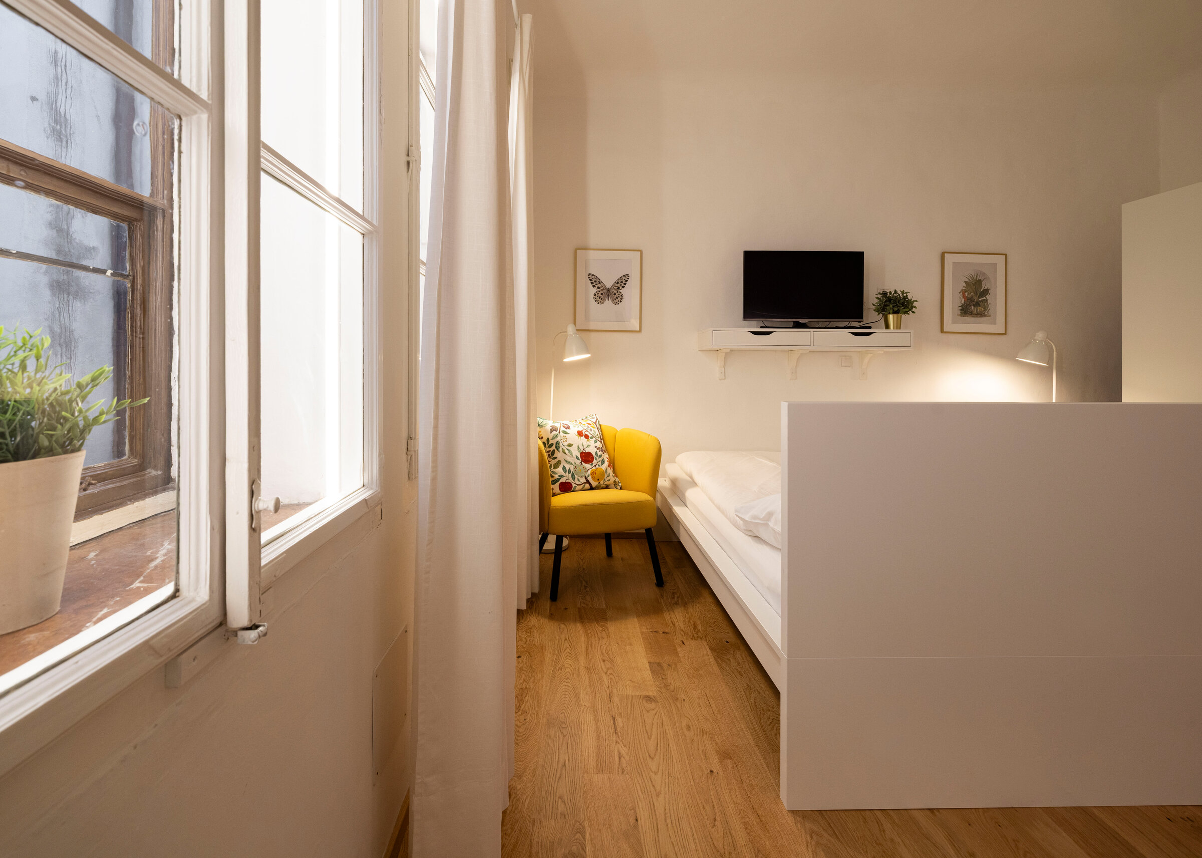 Helles 1-Zimmer Apartment mit Holzboden & gelbem Sessel – Wohnen auf Zeit & Kurzzeitmiete Salzburg, 1 bis 6 Monate