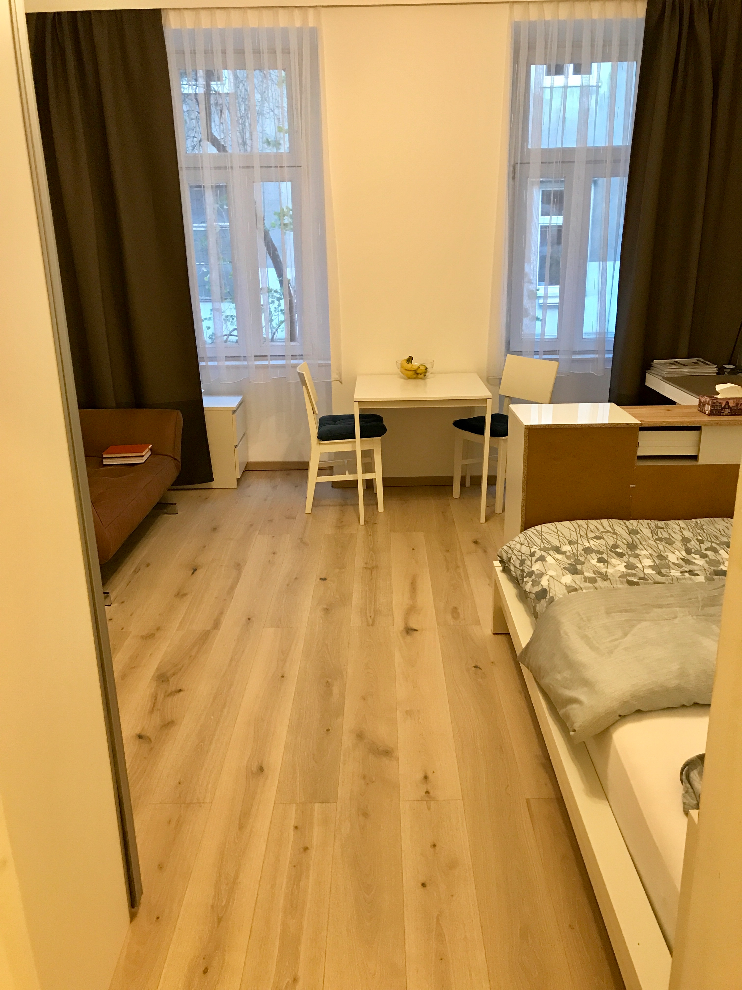 Bright room with dining table & wood floor – 1-room apartment, short-term rental, temporary housing for 1 to 6 months, Vienna | © Clemens Fontner