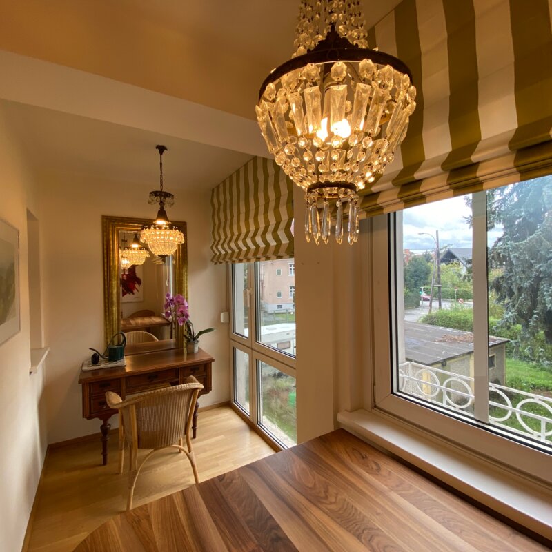 Elegant dining area with crystal chandelier & park view – 2-room apartment, short-term rental in Graz