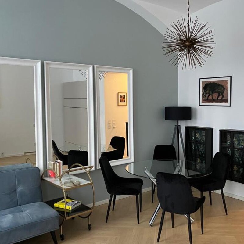 Stilvolles Wohnzimmer mit Designmöbeln & Glasstisch – 1-Zimmer Wohnung zur Kurzzeitmiete & Wohnen auf Zeit für 1 bis 6 Monate in Wien | © Franziska Ehrenfellner 