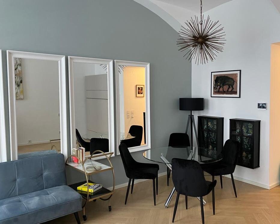 Stilvolles Wohnzimmer mit Designmöbeln & Glasstisch – 1-Zimmer Wohnung zur Kurzzeitmiete & Wohnen auf Zeit für 1 bis 6 Monate in Wien | © Franziska Ehrenfellner 