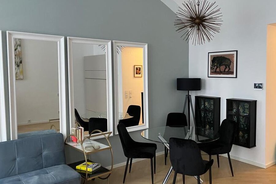 Stilvolles Wohnzimmer mit Designmöbeln & Glasstisch – 1-Zimmer Wohnung zur Kurzzeitmiete & Wohnen auf Zeit für 1 bis 6 Monate in Wien | © Franziska Ehrenfellner 