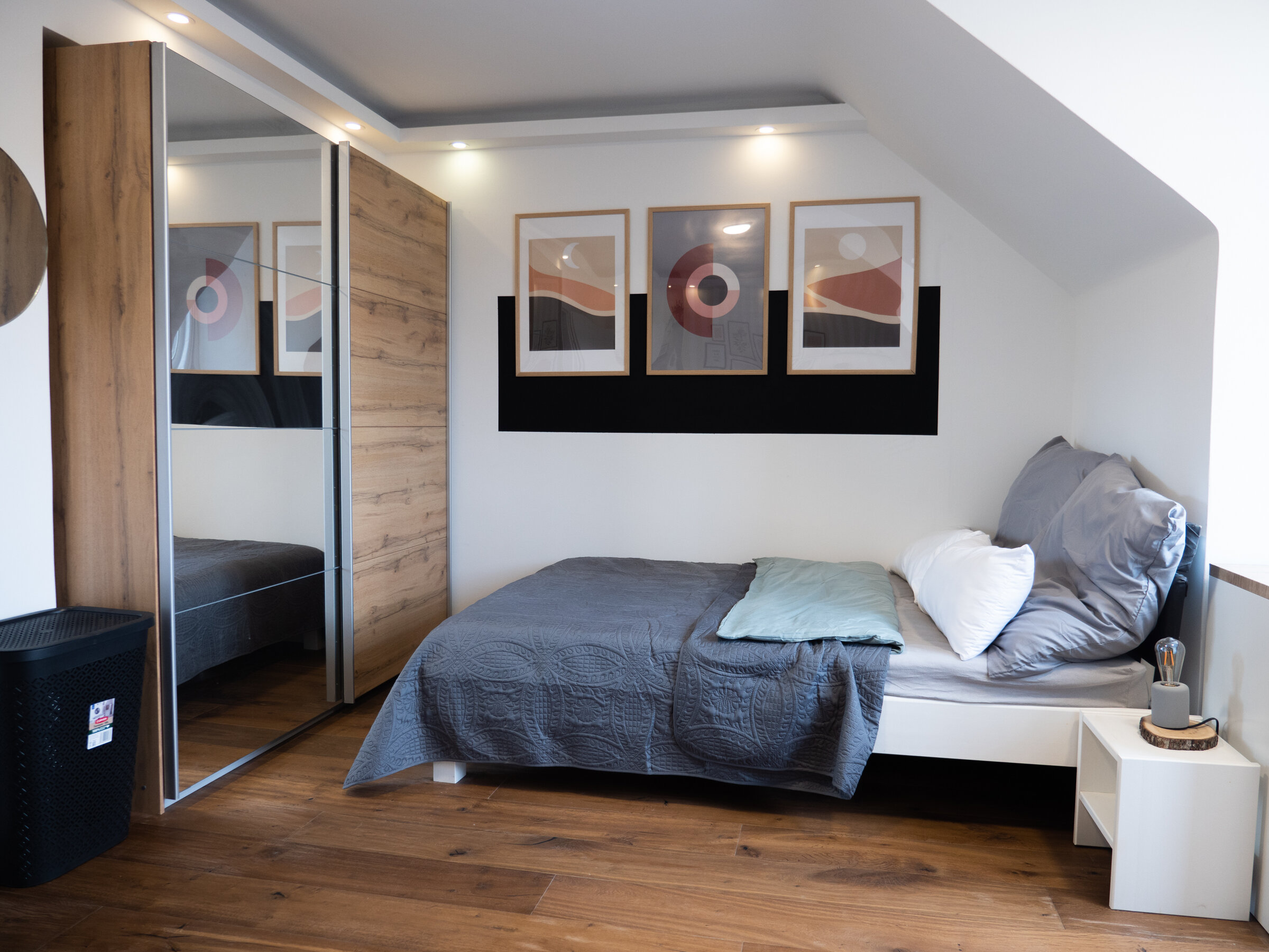 Modern bedroom with wood floors & mirrored wardrobe – 3-room apartment, short-term rental Vienna, 1–6 months