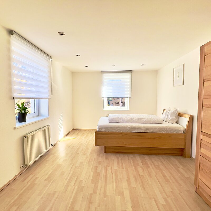 Helles Schlafzimmer mit Holzbett & Parkettboden – 4-Zimmer Wohnung Kurzzeitmiete Innsbruck, Wohnen auf Zeit 1–6 Monate