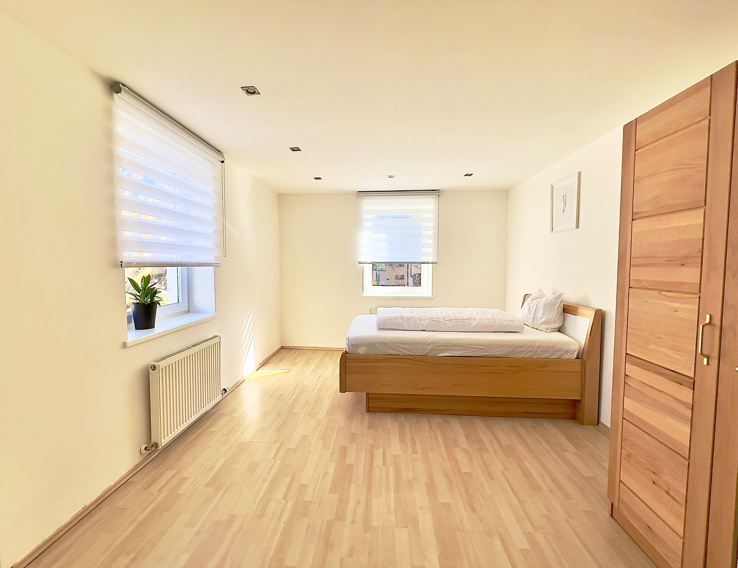 Helles Schlafzimmer mit Holzbett & Parkettboden – 4-Zimmer Wohnung Kurzzeitmiete Innsbruck, Wohnen auf Zeit 1–6 Monate