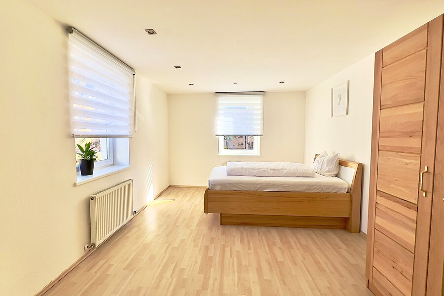 Helles Schlafzimmer mit Holzbett & Parkettboden – 4-Zimmer Wohnung Kurzzeitmiete Innsbruck, Wohnen auf Zeit 1–6 Monate